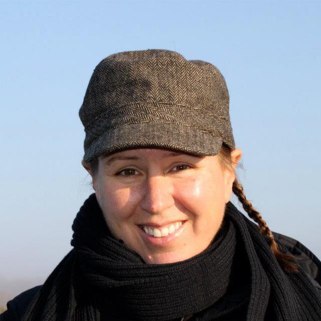 Christine Quane, a white woman wearing a hat, smiles
